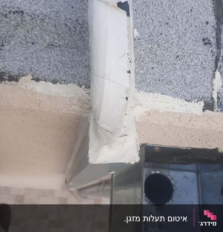 איטום צינור עם חומר איטום לבן על קיר